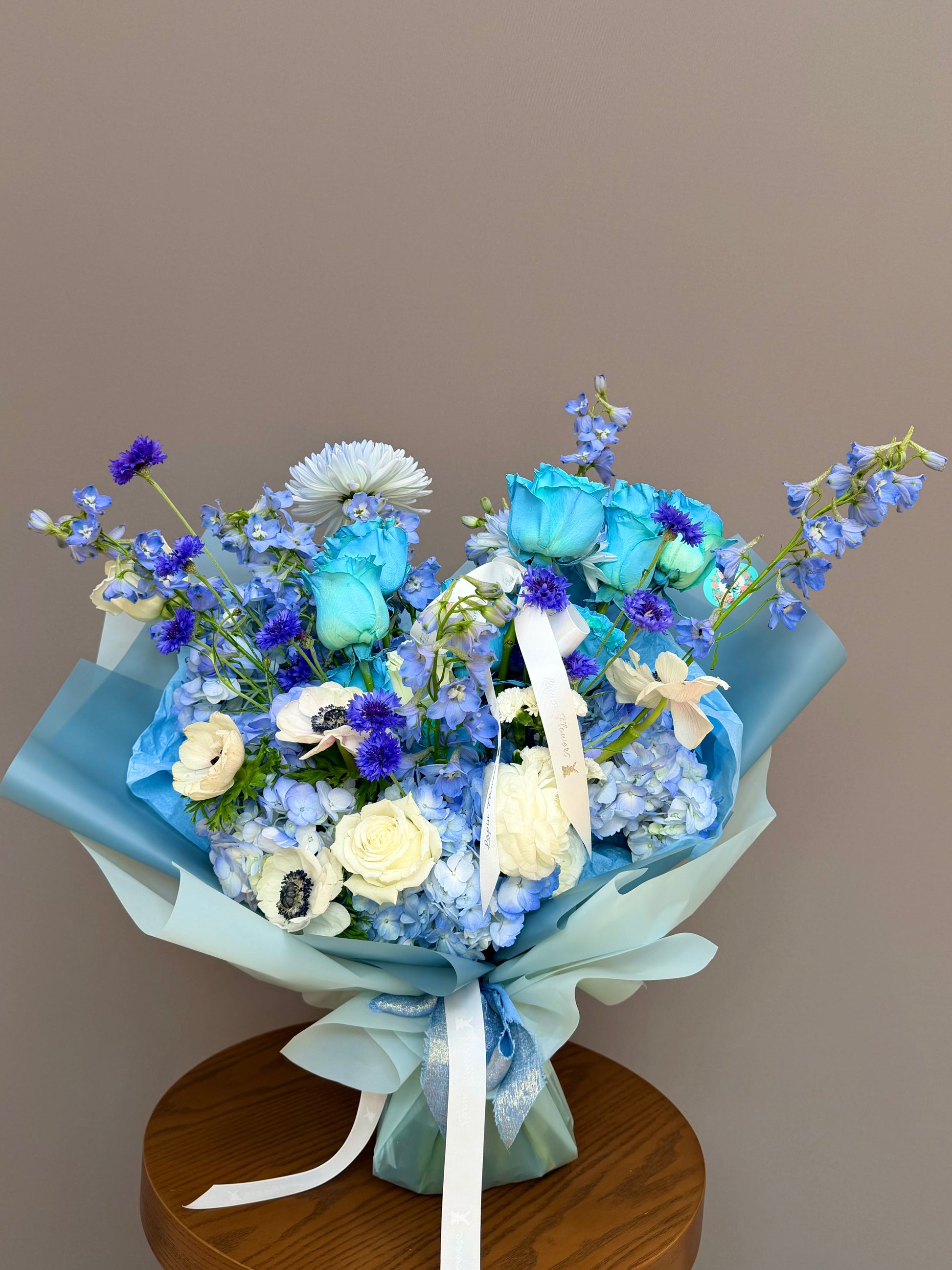 Bouquet for honor of John Hopkins.
Extra-large luxury artisan flower bouquet featuring premium dyed blue roses, white anemones with black centers, blue delphinium, and blue hydrangea wrapped in ice-blue paper by Lapin Flowers. Upscale elite floral design for delivery in Maryland, Washington DC, and Virginia.⁠
