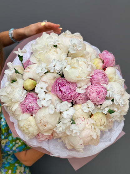 Extra-large luxury artisan bouquet with peach roses, yellow lisianthus, and yellow butterfly ranunculus in a striking yellow and peach wrapping paper by Lapin Flowers, premium flower delivery in Washington DC,  Maryland and Northwest Virginia. 