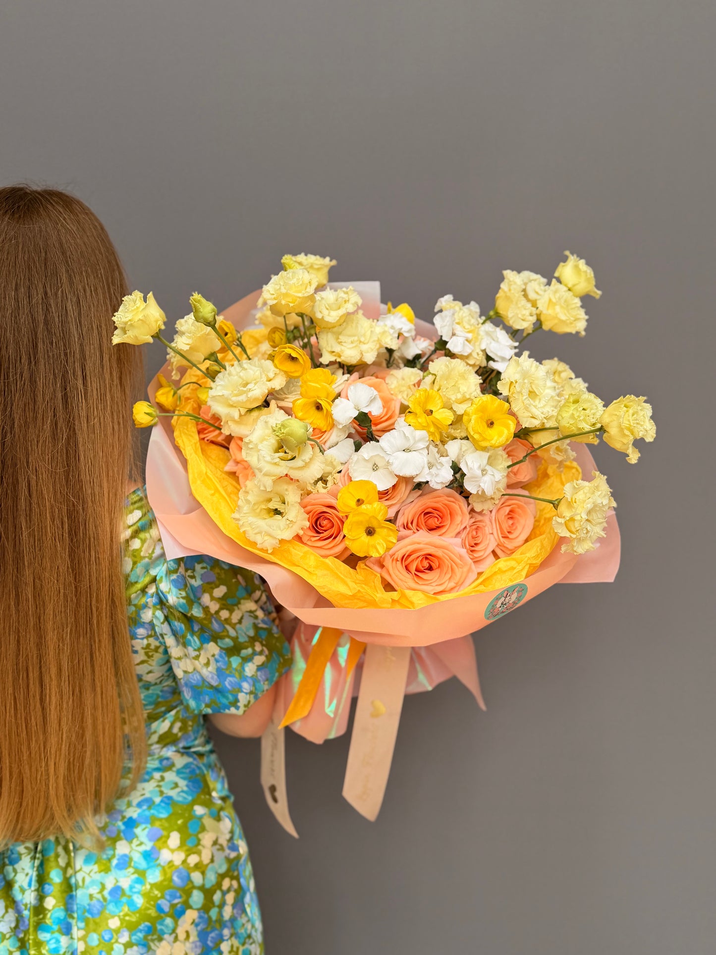 Extra-large luxury artisan bouquet with peach roses, yellow lisianthus, and yellow butterfly ranunculus in a striking yellow and peach wrapping paper by Lapin Flowers, premium flower delivery in McLean, VA, and Maryland.