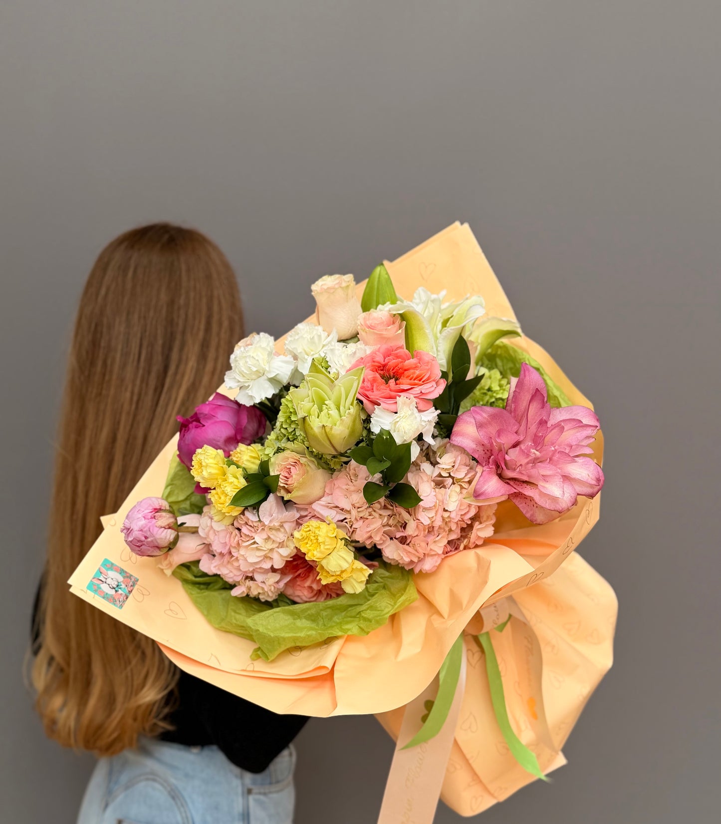 Extra-large luxury artisan flower bouquet with a double pink lily, blush pink hydrangea, garden roses, and pastel carnations wrapped in peach and green paper by Lapin Flowers. Upscale elite delivery for Potomac Maryland and Washington DC.⁠