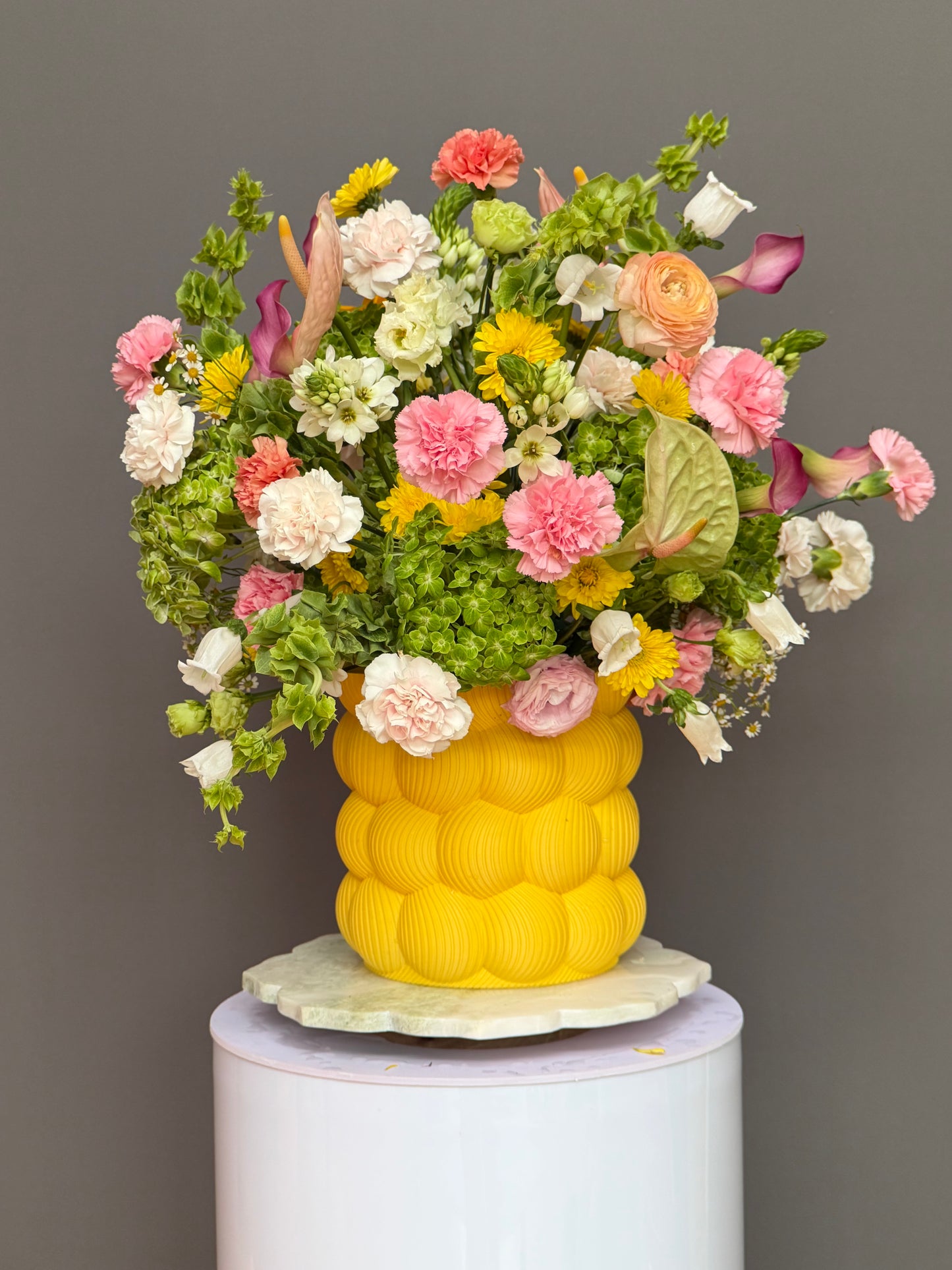 Close up of pink anthuriums and green hydrangeas in sculptural yellow vase luxury flower delivery Washington DC Georgetown Lapin Flowers