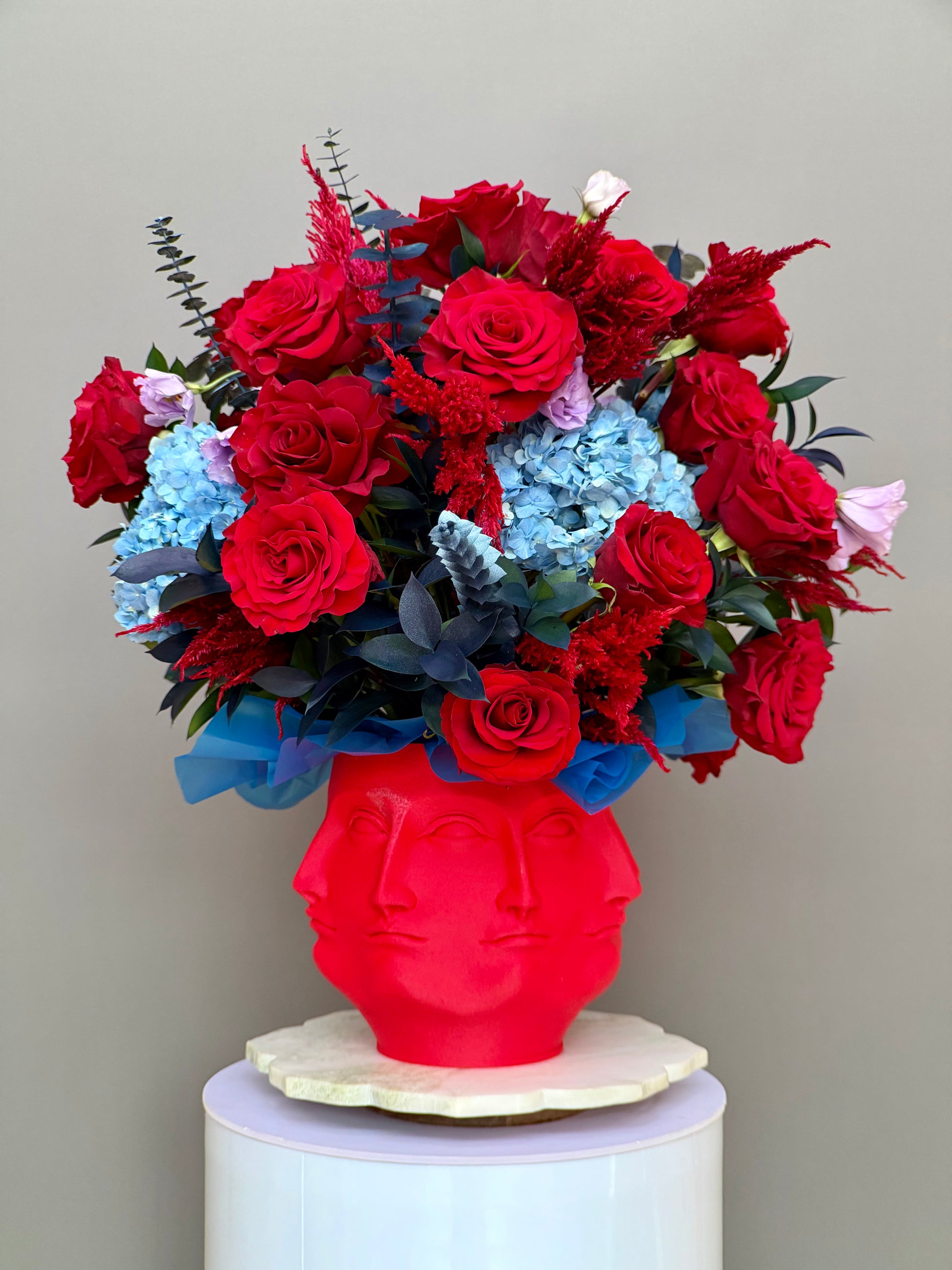 Face It Crimson Allure red roses and blue hydrangea arrangement in red Face It multi face vase by Lapin Flowers Potomac MD DC