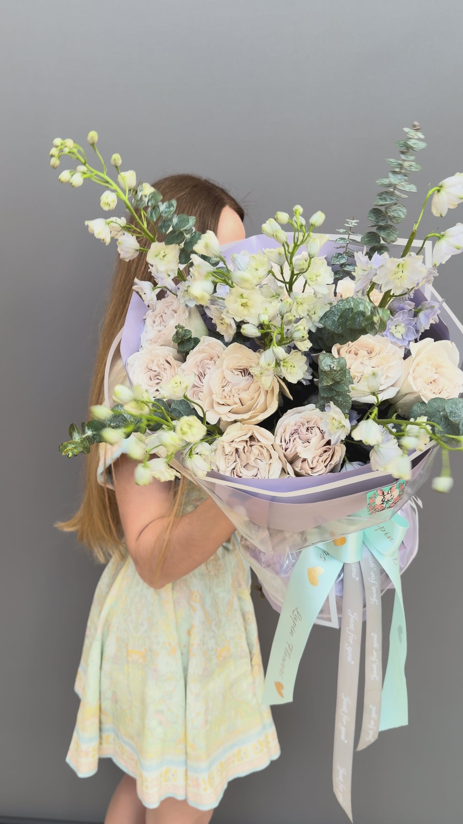 Luxury couture flower bouquet featuring Westminster Abbey sand-beige garden roses, white delphinium, and eucalyptus by Lapin Flowers. Upscale floral art in lavender wrapping paper for delivery in Northern Virginia, Washington DC, and Maryland.⁠