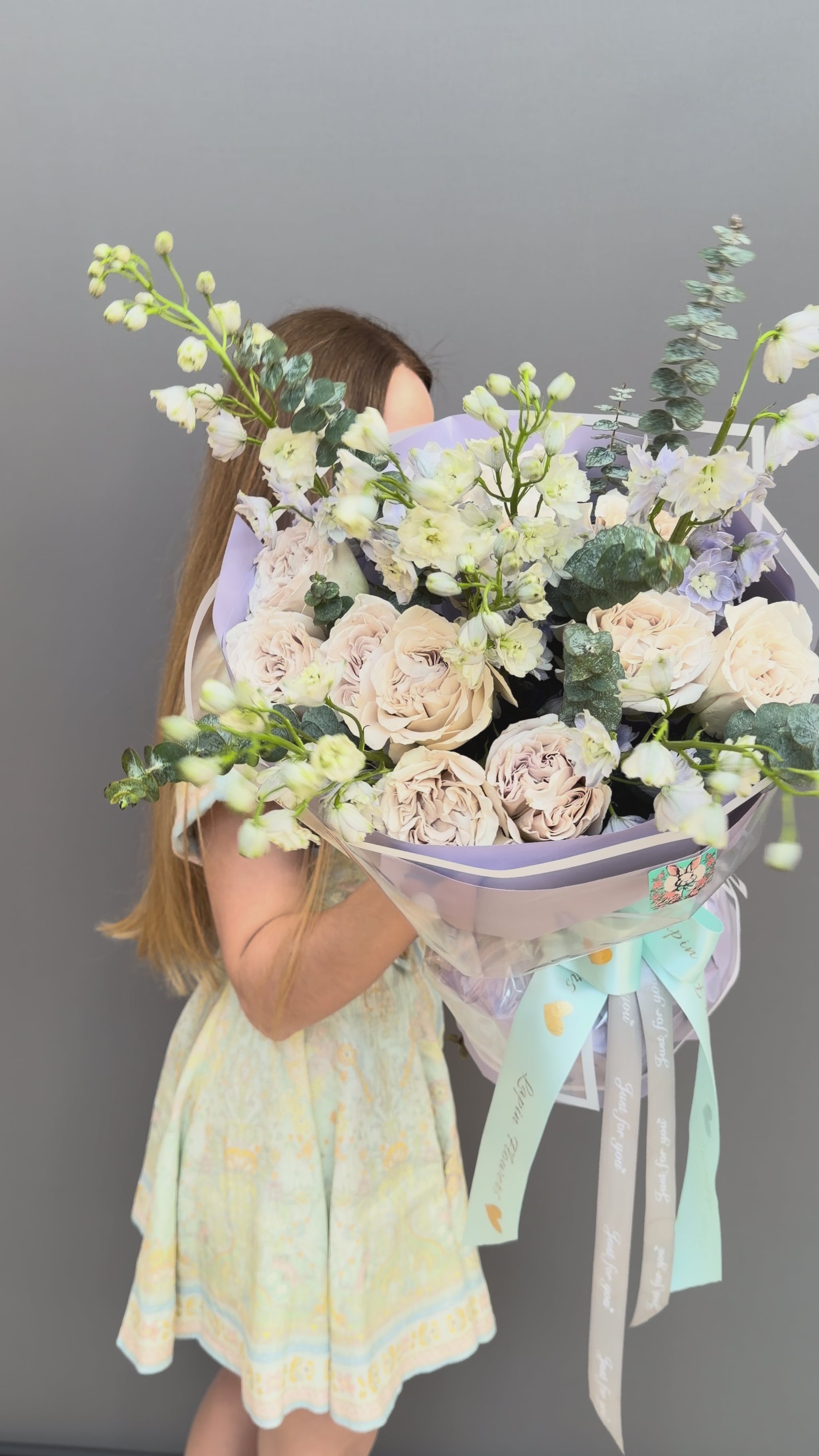 Luxury couture flower bouquet featuring Westminster Abbey sand-beige garden roses, white delphinium, and eucalyptus by Lapin Flowers. Upscale floral art in lavender wrapping paper for delivery in Northern Virginia, Washington DC, and Maryland.⁠
