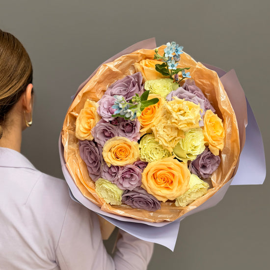 Extra-large luxury artisan flower bouquet with peach roses, white lilies, white lisianthus, and green button mums wrapped in bright yellow and frosted paper by Lapin Flowers. Premium flower delivery for Washington DC and Maryland.