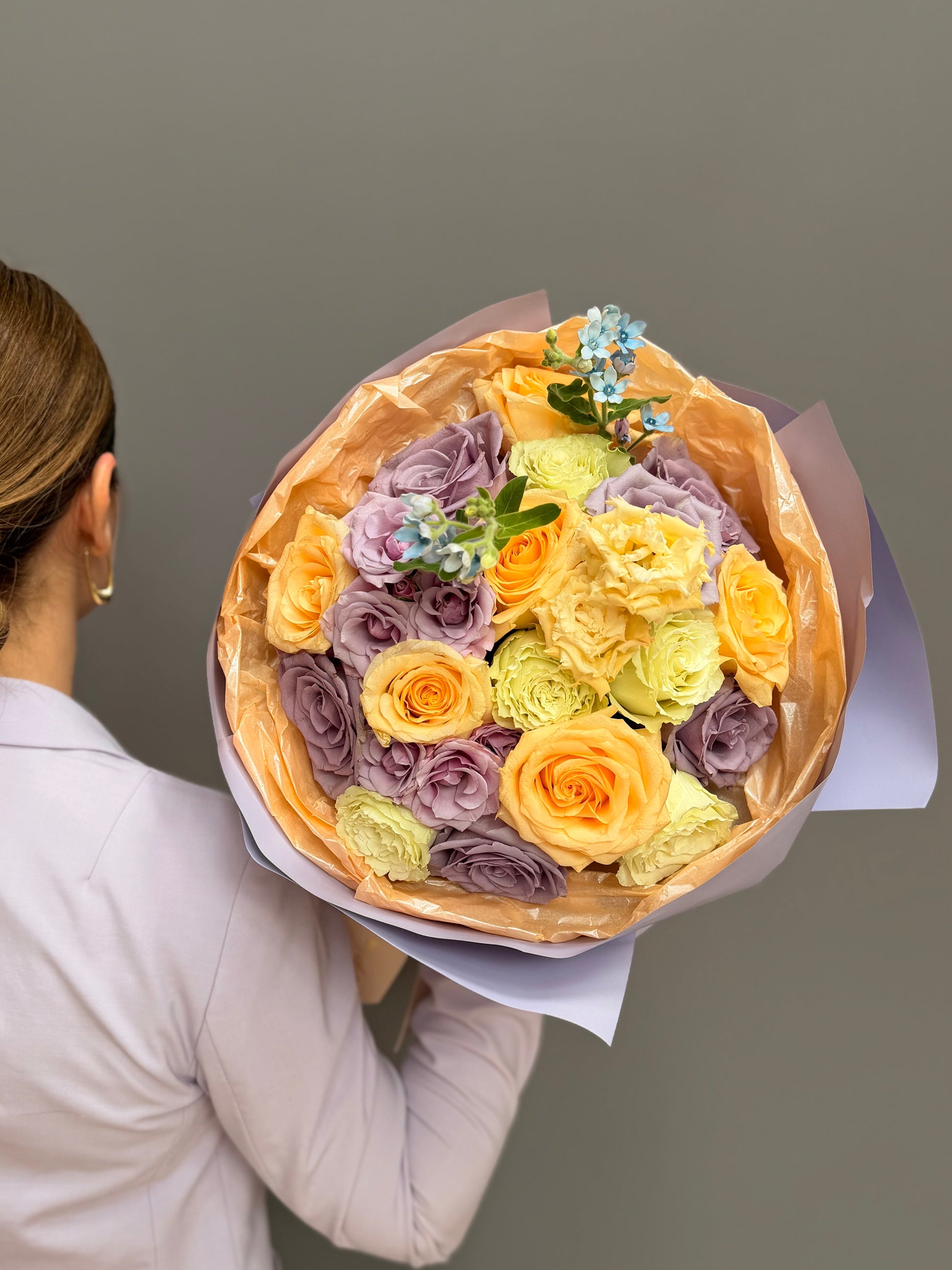 Extra-large luxury artisan flower bouquet with peach roses, white lilies, white lisianthus, and green button mums wrapped in bright yellow and frosted paper by Lapin Flowers. Premium flower delivery for Washington DC and Maryland.