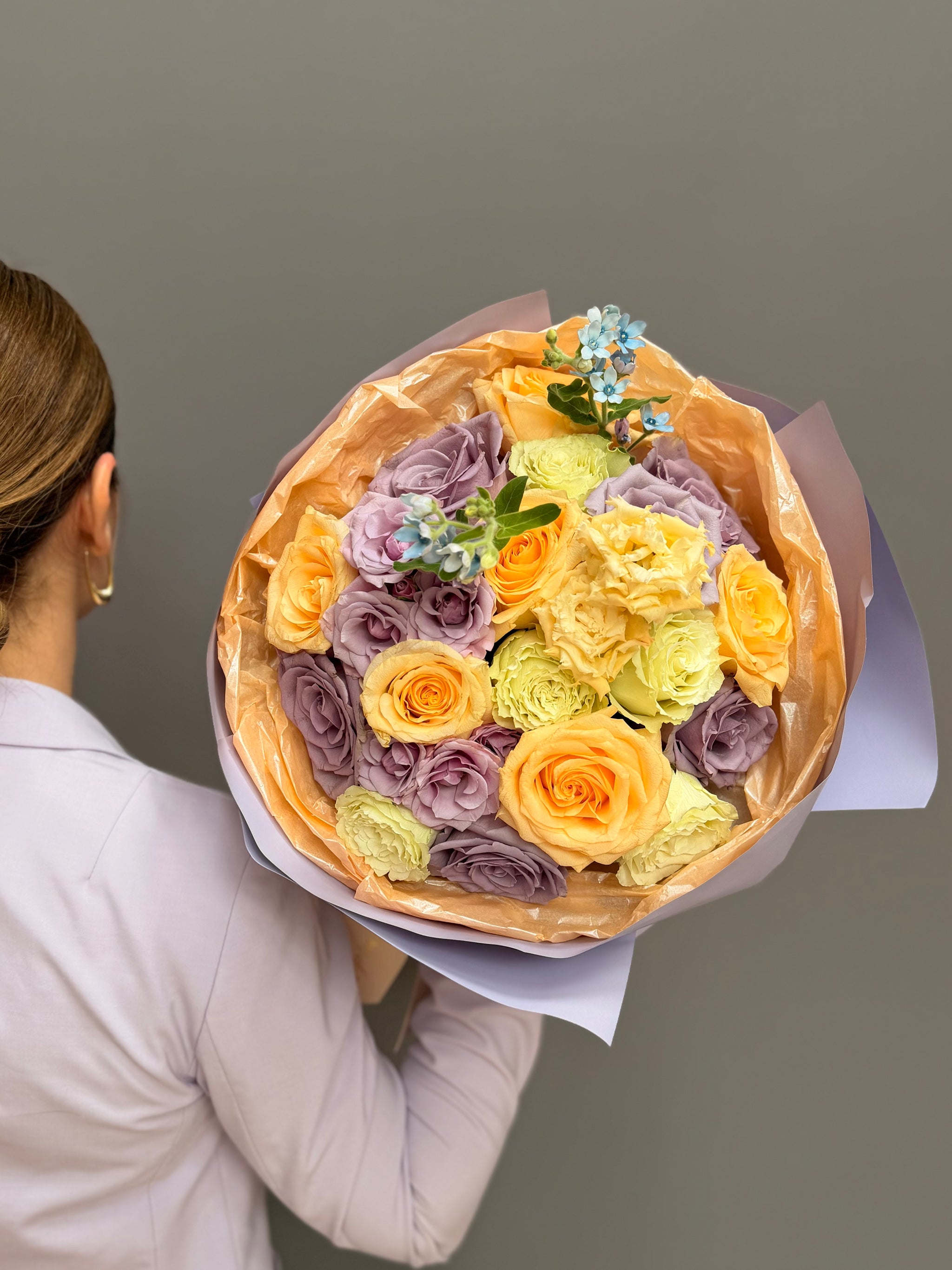 Extra-large luxury artisan flower bouquet with peach roses, white lilies, white lisianthus, and green button mums wrapped in bright yellow and frosted paper by Lapin Flowers. Premium flower delivery for Washington DC and Maryland.