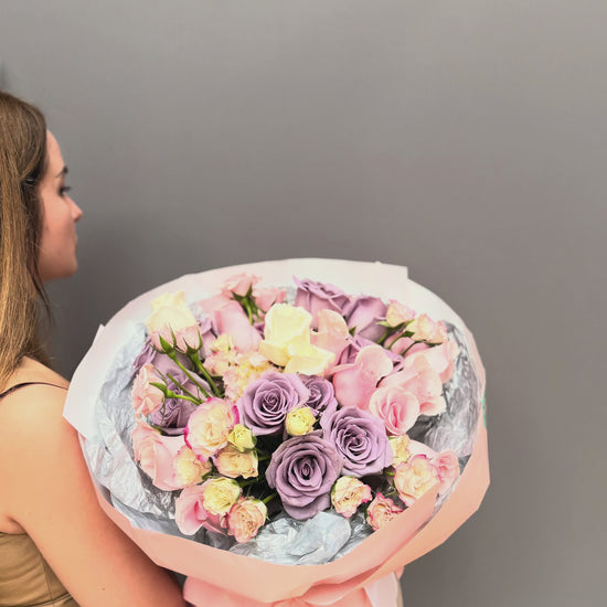 Premium luxury artisan bouquet with dusty lavender roses, blush pink roses, and pastel spray roses wrapped in peach and silver paper by Lapin Flowers. Upscale elite flower delivery for Bethesda Maryland and Washington DC.⁠