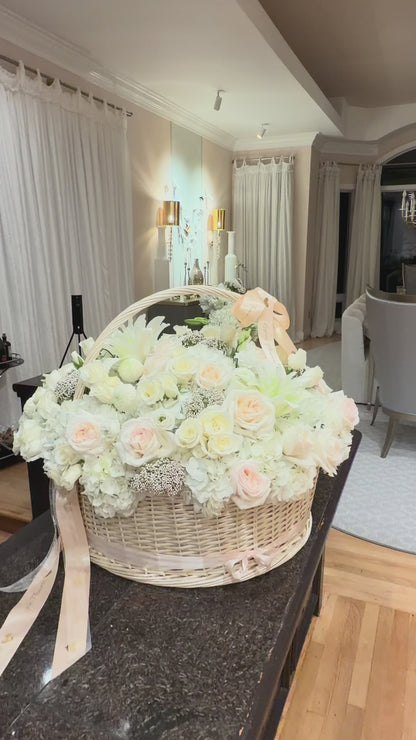 Large-scale luxury white flower basket by Lapin Flowers for an engagement in Maryland. Featuring 25 premium Jumbo white hydrangeas, blush O'Hara garden roses, and white lilies in a 24-inch wicker basket. Professional floral installation for upscale events in the MD, VA, and DC area.