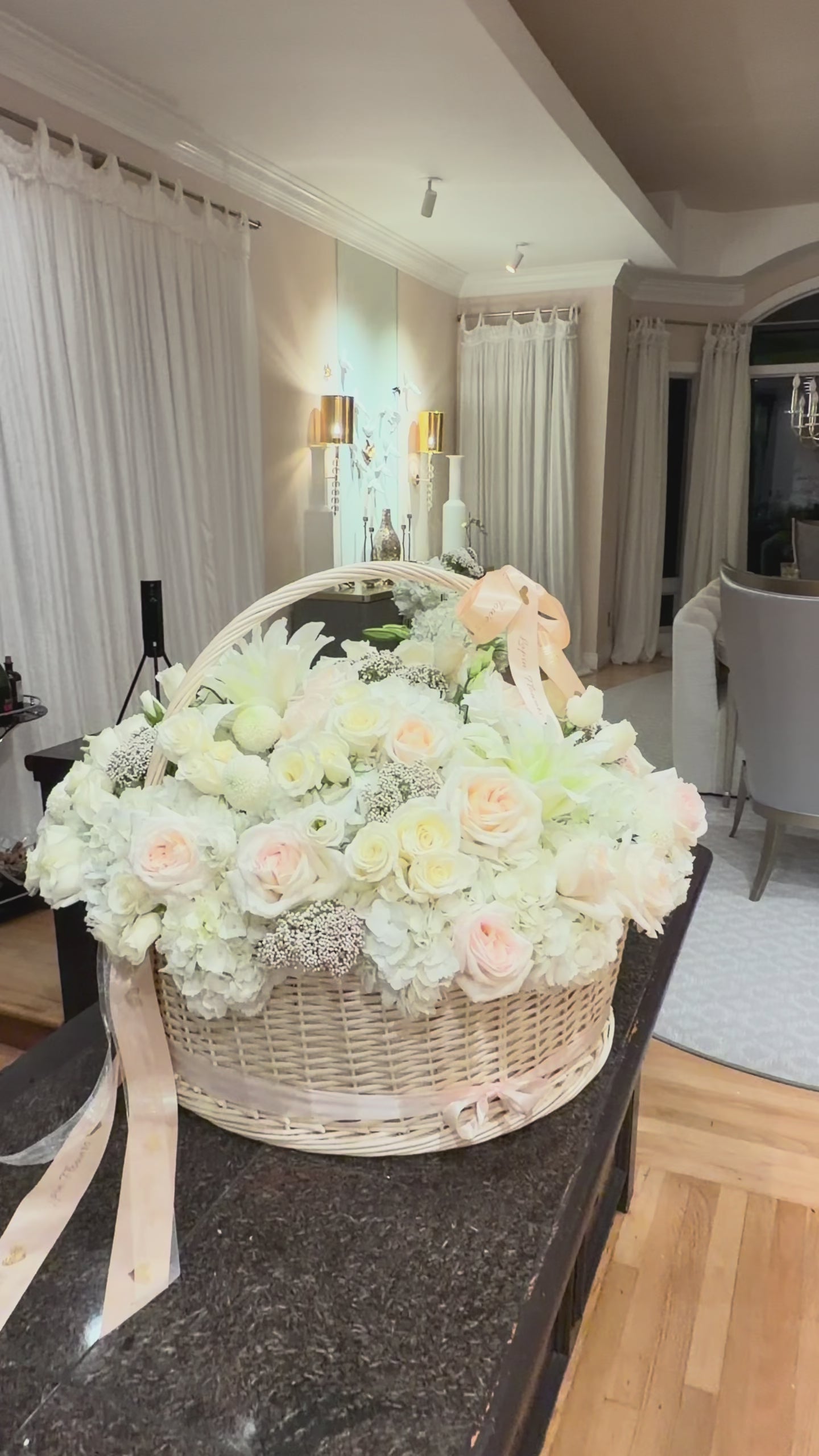 Large-scale luxury white flower basket by Lapin Flowers for an engagement in Maryland. Featuring 25 premium Jumbo white hydrangeas, blush O'Hara garden roses, and white lilies in a 24-inch wicker basket. Professional floral installation for upscale events in the MD, VA, and DC area.
